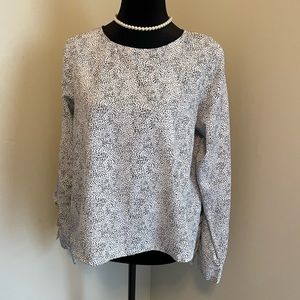 Black and white ruffled and open arm blouse